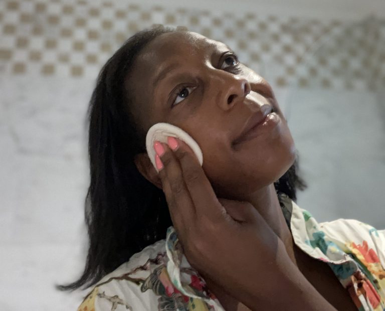 Black woman using reusable textured makeup remover pad